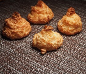 Four round pieces of cookies lie on the brown tablecloth. Still-life.