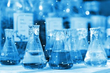 Chemical beaker in laboratory with atomic chart