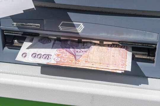 Withdraw money from ATM. 100 ISK banknotes at ATM machine.