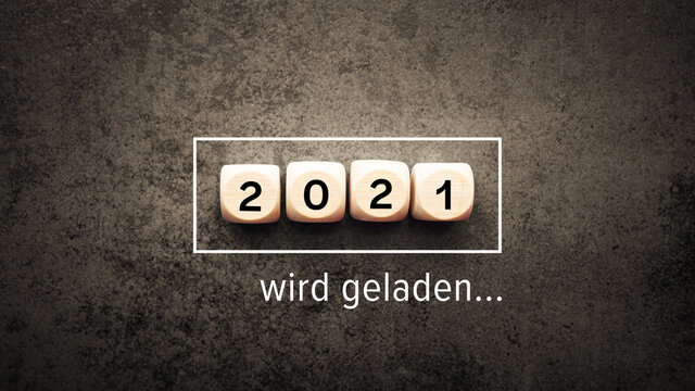 2021 wird geladen. W&uuml;rfel mit Jahr 2021 auf einem dunklen Hintergrund.
