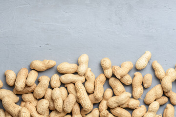 Spilled peanuts on a concrete surface with copies of space. Top view.