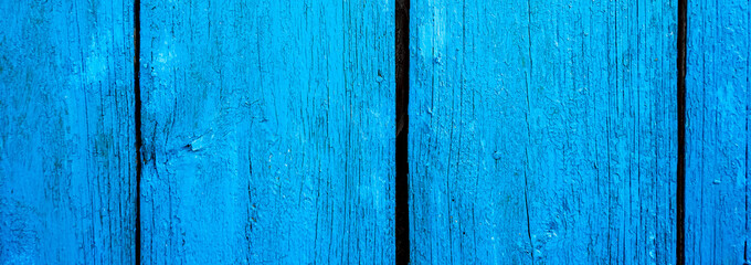 Wooden protection on all background, is painted light blue. old cracked blue paint on wood flooring.