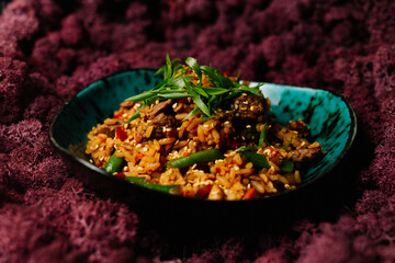 Homemade Chinese fried rice with vegetables, chicken and fried eggs served on a plate with chopsticks (Selective Focus, Focus one third into the dish)