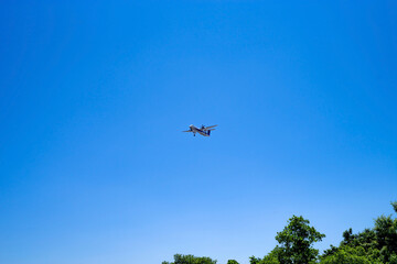青空と着陸態勢の旅客機・プロペラ機