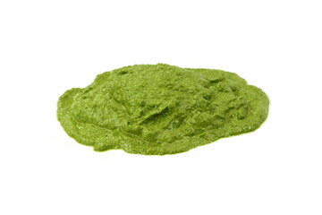 Pesto spread or blob in a bowl isolated on white background. Green italian homemade spilled sauce made of ground basil, garlic, pine seeds, olives and pecorino sardo cheese 