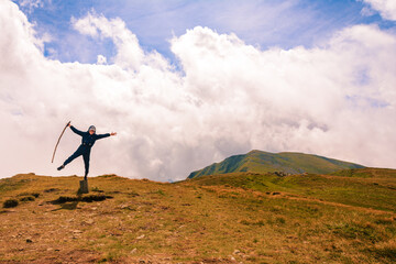 A tourist on top of the mountain opened his arms like a bird, enjoying the height and majesty of the mountains.