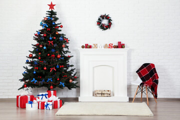 Christmas fir tree with ornaments and gift boxes near decorated fireplace at home