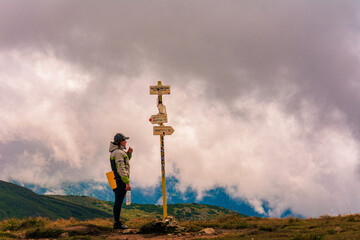 The tourist studies the indicator in the mountains, the direction to move further, the Montenegrin...