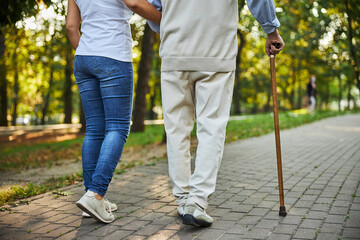 Young woman holding hand of senior man in the street