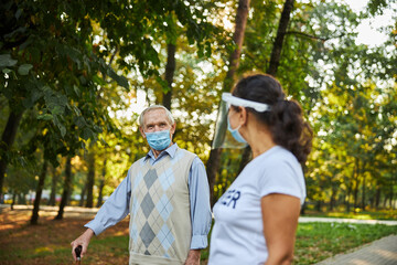 Naklejka premium Elderly man in casual clothes looking to the woman social worker