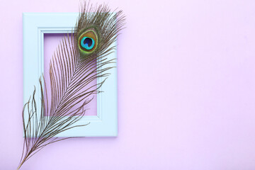 Peacock feather with wooden frame on puple background