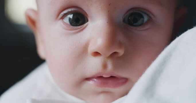 Authentic close up shot of a cute newborn baby is smiling in the camera. 