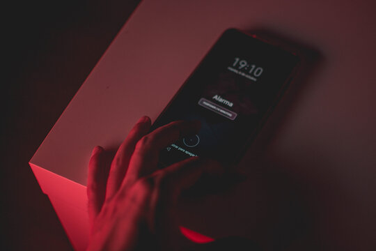 Mano apagando una alarma con luz roja