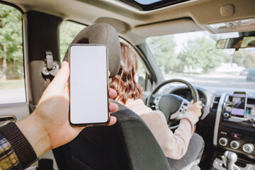 man hand holding phone with white screen woman driving car