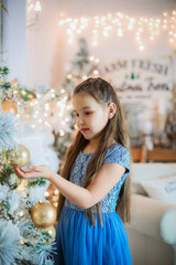 young girl in blue dress on the Christmas background