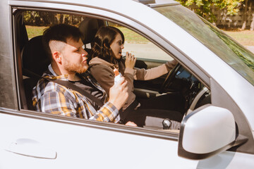 couple having chocolate snack while riding in car