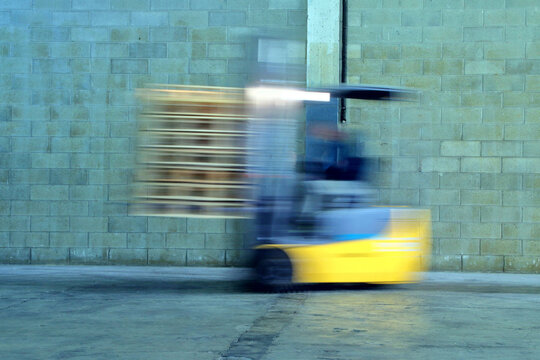 magazziniere e muletto in magazzino, warehouse worker and forklift in the warehouse