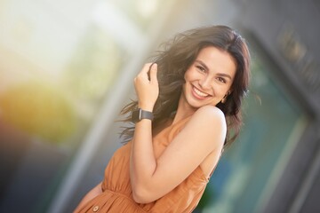 Portrait of a young happy attractive caucasian woman wearing summer dress looking at camera and...