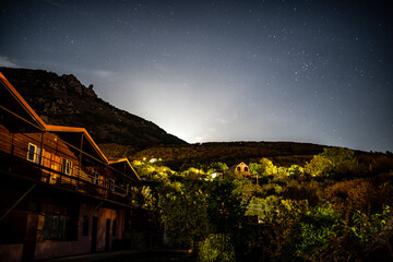 night panoramic view of the mountain village and blue sky with stars