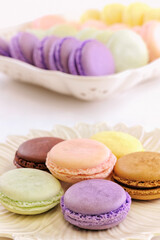 Assorted macarons a French confectionary dessert.  Yellow lemon citron. green pistachio,  purple pink cassis and raspberry. 