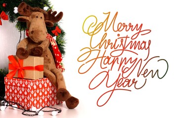 Christmas card. Merry Christmas and Happy New Year. Text with a toy Christmas deer and gifts on a white background