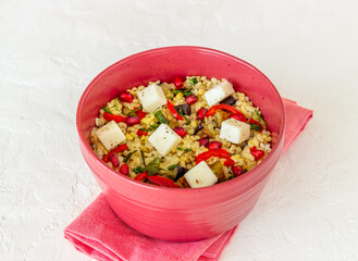 Bulgur with cheese, pepper, eggplant and pomegranate. Healthy eating. Vegetarian food. Diet.