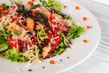 summer vegetable salad on a white dish on a wooden background