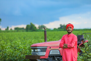 Technology and people concept, Portrait of young indian farmer with tractor