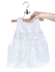 White dress for baby on hanger in hand on white background isolation