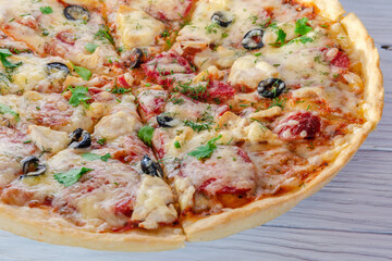 pizza with cheese vegetables and meat on a wooden background