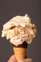 Melting raspberry ripple ice cream on a chocolate-dipped cone