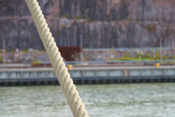 Naklejka premium Mooring rope with blurred river on the background.