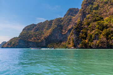 Obraz premium A view of boats passing a limestone island in Phang Nga Bay, Thailand