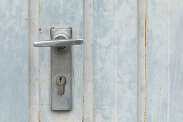 Weathered closed garage door with lock and keyhole, space for text and no person
