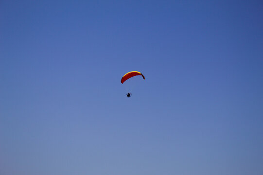 Parapente motorizado voando com o fundo do c&eacute;u azul