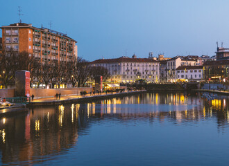 Stunning blue hour view of Darsena in the touristic district of Milan. Large body of water where the lights of the city are reflected. Lombardy, Italy