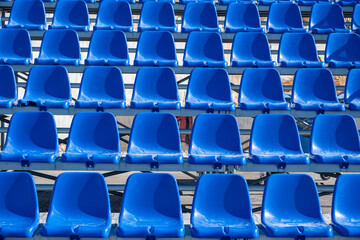 Stadium seats background. Rows of blue plastic empty chairs