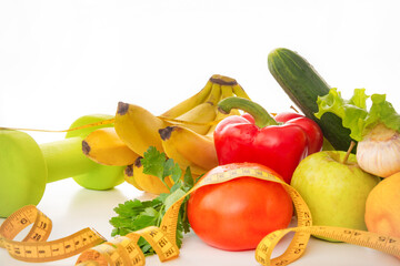 vegetables, fruits, dumbbells, measuring tape on a white background, healthy food
