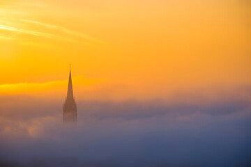 Church of the Sacred Heart of Jesus surrounded by fog and clouds, in Graz, Styria region, Austria, at sunrise. Beautiful foggy morning over the city of Graz, in autumn