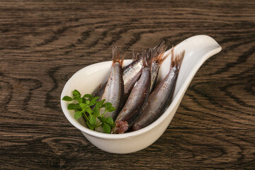 Anchovies in the bowl served basil leaves