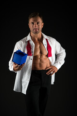 Strong man with six pack ab torso in open shirt hold present box black background, gift