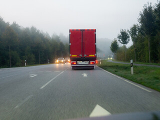  red truck driving on a foggy country road