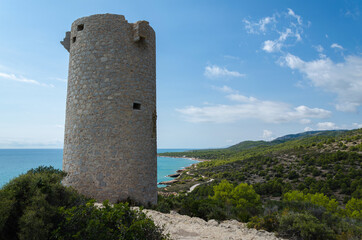 Natural landscape of Sierra de Irta Park with Badum sentinel tower on a summer day with blue sky,...