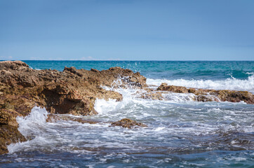 Sea waves break against the rocky coastline in Sierra de Irta Natural Park, Castellon, Spain