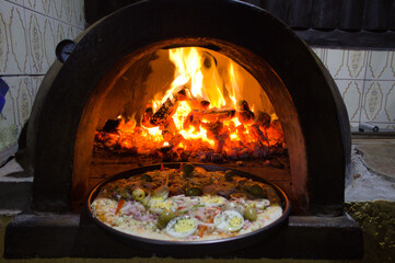 Pizza portuguesa com ovo assada no forno a lenha