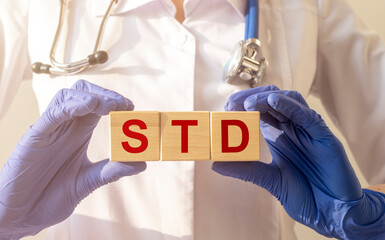 STD, Sexually transmitted infections, acronym text on wooden cubes in doctor hands in gloves