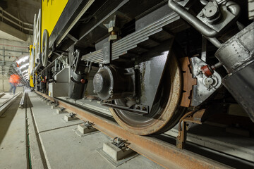 Closeup of the railway maintenance vehicle. Train wheels on rails.