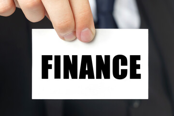 Businessman shows a card with the text FINANCE