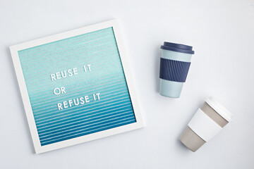 Reusable coffee cup and letterboard with text reuse it or refuse it. Zero waste sustainable lifestyle