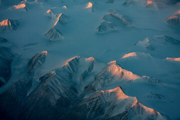 Aerial view of snowy mountain peaks of Greenland during sunset © Moe Shirani